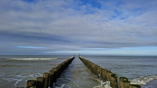 Meeuwen op de golfbreker palen in Domburg, wat bewolking en de zon was begin van de middag langzaam aan het verdwijnen