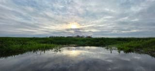 Zon vanuit de bewolking boven de Groninger landerijen 