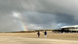 Regenboog strand tegenlicht