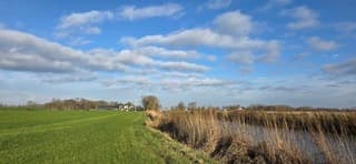 Blauw bewolkte lucht en zon boven de provincie Groningen 