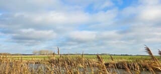 Blauw bewolkte lucht en zon boven de provincie Groningen 