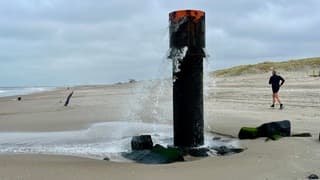 De uitstroompaal op het strand met de overloopfunctie voor het achterland 