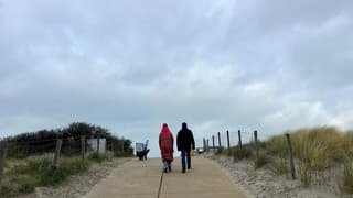 warm aangekleed met de hond op weg naar het strand om uit te waaien aan zee 
