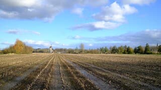 Zon, wolken een najaarslanfschap en Hollandse molen