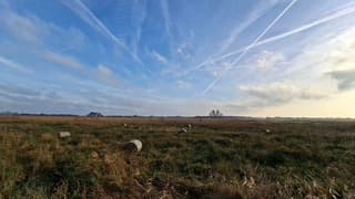 Wolken en strepen in de lucht, rietbalen in het veld in het dorpje Nederland