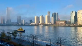 Zon en  mist bij de wolkenkrabbers aan de Maas 