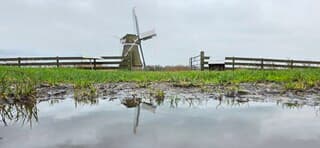 Bewolking en weerspiegeling in een regenplas vanmiddag 