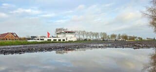 Prachtige weerspiegeling in het water van een regenplas 