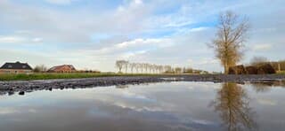 Prachtige weerspiegeling in het water van een regenplas 