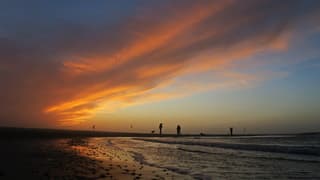 De zon is onder en kleurt de wolken