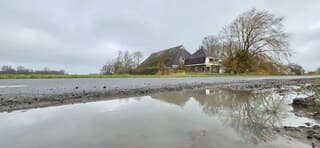 Bewolking en weerspiegeling in een regenplas vanmiddag 