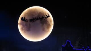 De Kerstman met de arrenslee voorbij de maan