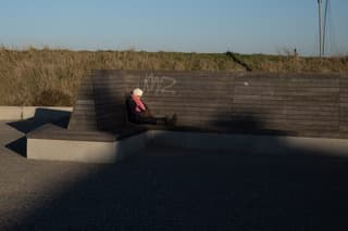 Oudere vrouw slaapt in de zon op de boulevard