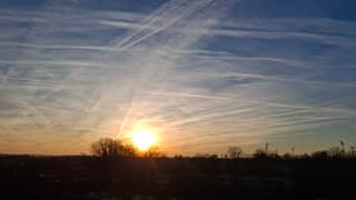 Veel vliegtuigstrepen bij zonsopkomst