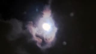 De maan tijdens een opening in het wolkendek 