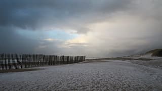 Na de hagelbui is het strand even wit