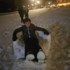 Luuk zit in zijn eigen gemaakte sneeuwstoel! 