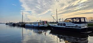 Blauw bewolkte lucht en zon boven de haven in Zoutkamp 