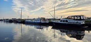 Blauw bewolkte lucht en zon boven de haven in Zoutkamp 