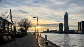 Langzaam zakt de zon. achter de Erasmusbrug 