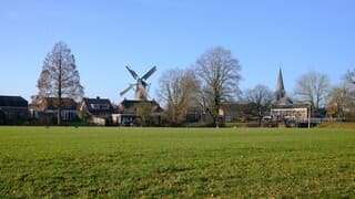 Zon, blauwe lucht en wat wind op zonnige dag in Midden-Nederland met dorpsgezicht