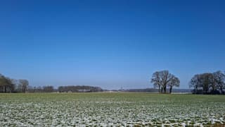 Zonnig uitzicht met kerkje in de verte