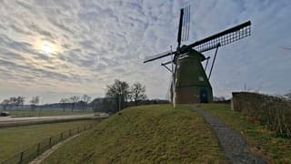 De zon schijnt door het wolkendek boven de Fleringermolen