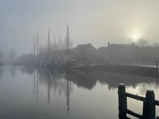 De felle zon piept door de mist