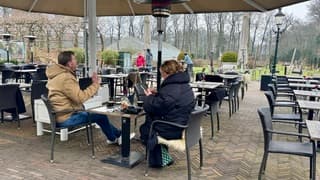 Op terras in dikke jas