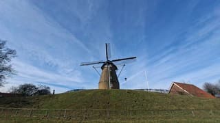 Zonnig, blauwe luchten en wat bewolking boven deze molen