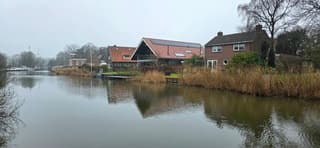 Grijs nat weer en weerspiegeling in het water in Winsum 