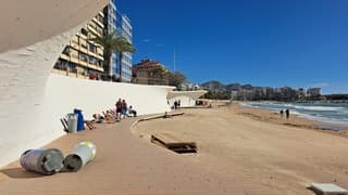 Omgewaaide prullenbakken op het strand 