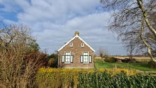Idyllisch huisje in Munnekeburen vanochtend in een half zonnig en bewolkt Munnekeburen