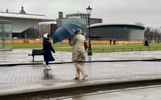 Dat is een best windje. Onderweg naar het concertgebouw probeert deze mevrouw droog aan te komen maar de harde wind heeft andere plannen. 