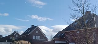 Lenticularis wolken boven de huizen 