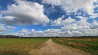 Voorjaar opent de lucht boven een stille landweg