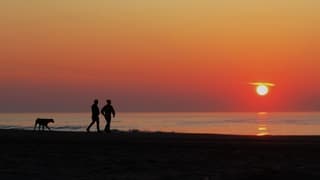 Langs de vloedlijn bij zonsondergang