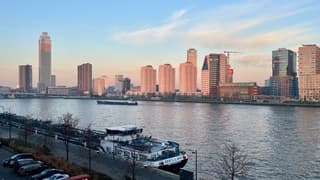 Opkomende zon kleurt de woontorens  aan de Nieuwe Maas 