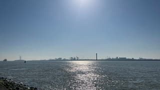 Gesluierd zonlicht in baan over de Nieuwe Waterweg 