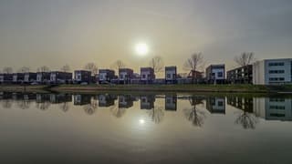 Beige lucht met zon en windstil, weerschijn in het water