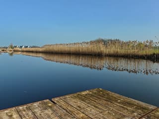 Spiegelglad water bij een staalblauwe lucht