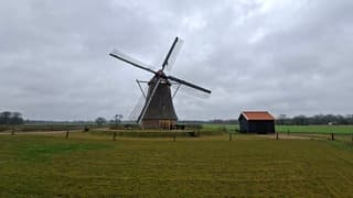 Deze molen draait bij aardig wat wind en onder grijze lucht en regen