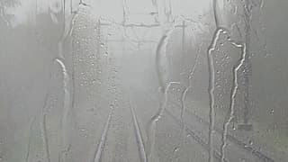 De regen stuift achter de trein in Tilburg 