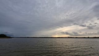 Half uur voor zonsondergang, glimp van de zon en donkere wolken