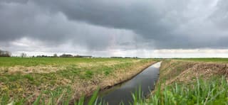 Vallende regen en donkere regenwolken bij Noordhorn 