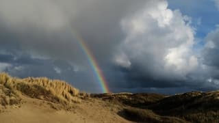 Regenboog boven de duinen
