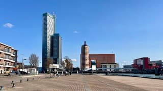 Aan de horizon bij de Kop van Zuid wat kleine witte  wolkjes 