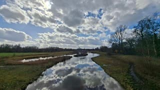 Weerspiegeling van de vele stapelwolken en speldenprikje zon