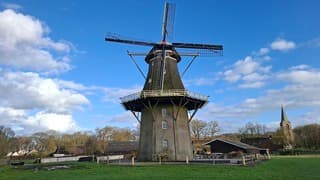 Blauwe lucht, zon en stapelwolken bij deze oude monumentale molen in Vilsteren