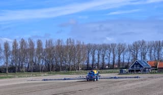 Boer al bezig te sproeien tegen onkruid